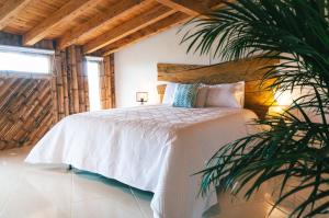 马里尼亚PIA COLOMBIA的卧室配有白色的床和棕榈树