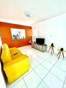 佩罗巴Casa de Luxo em Maragogi的客厅设有黄色沙发和电视