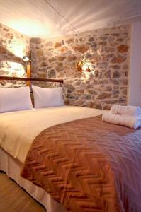 伊兹拉Braxos A beautiful rocky place的一间卧室设有一张带石墙的大床