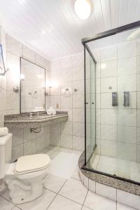 拉古纳Samba Laguna Tourist Hotel的一间带卫生间和玻璃淋浴间的浴室