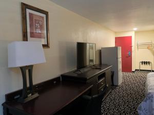 HiawathaFairBridge Inn Express Hiawatha的客房设有书桌、电视和冰箱。