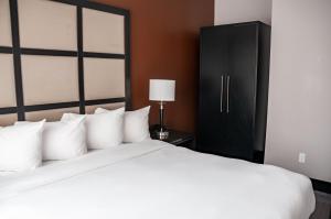 蒙特利尔M蒙特利尔旅馆的卧室配有白色的床和黑色橱柜。