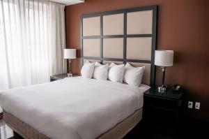蒙特利尔M蒙特利尔旅馆的一张大床,位于酒店带两盏灯的房间