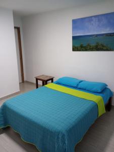Pampatar拉布朗奇拉别墅公寓的一间卧室配有一张蓝色和黄色毯子的床