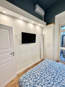都灵Casa Digione - vicino metro的卧室配有一张床,墙上配有电视。