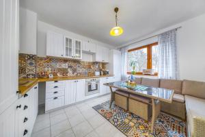 莱沃恰Apartmány Kašper的厨房配有白色橱柜、桌子和沙发