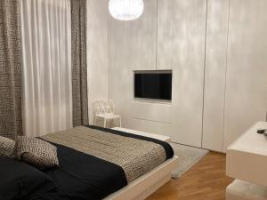 格罗塞托Thesan Lodge, chic & modern design apartment的一间卧室配有一张床和一台平面电视