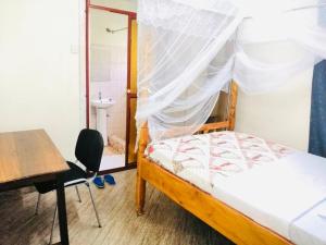 MbaleHome from home的一间卧室配有一张床、一张桌子和一把椅子
