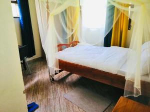 MbaleHome from home的一间卧室配有带窗帘的床和窗户