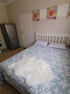 哈博罗内Country Block的卧室里的一张床上有白色毯子的床