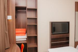 伊图Hotel e Pousada Bem Bom - Itu的客房设有衣柜、电视和床。