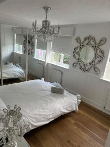 阿施Beautiful Little Bungalow, Indoor Fireplace, & Bar的一间卧室配有一张带镜子和吊灯的床。