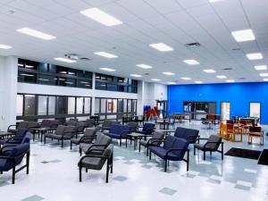 萨尼亚Residence & Conference Centre - Sarnia的一间空的等候室,配有蓝色的椅子和桌子