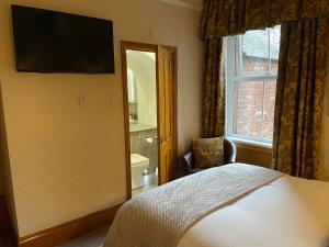 彭里斯Brooklands Guest House的一间卧室配有一张床、镜子和窗户