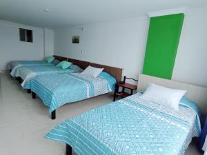 比亚维森西奥Diamante Blue Hotel的绿白色客房内的两张床