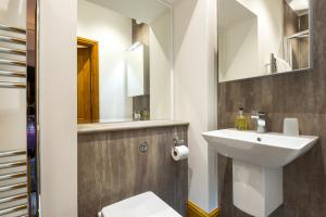 彭里斯Brooklands Guest House的一间带水槽、卫生间和镜子的浴室