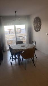 加鲁查Apartamento Andalucía - vistas al mar, playa, puerto deportivo, garaje的带阳台的客房内的餐桌和椅子