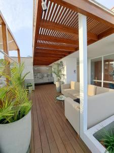 利马VK Loft - Apartamento en Miraflores的客厅铺有木地板,设有木制天花板。