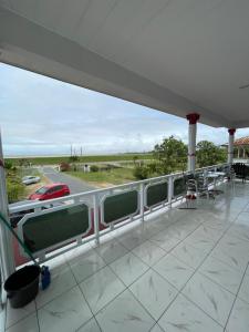 Nieuw NickerieZeedijk Resort Nickerie的海景阳台和汽车。