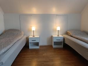 厄什塔Reinebu的配有两张床铺的房间,配有两盏灯