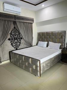 伊斯兰堡Oriole Luxury Hotel的一间卧室配有一张大床和大床头板
