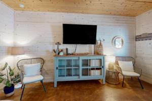 阿兰瑟斯港Mapacebo的客厅配有两把椅子和墙上的电视