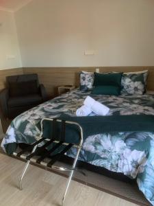 MerriwaMerriwa Golden Fleece Motor Inn & Lodge incorporating Merriwa Motor Inn & Motel的一间卧室配有一张带椅子和沙发的床