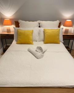 卡迪夫Cardiff Home的一张带两个黄色枕头和两个灯的白色床
