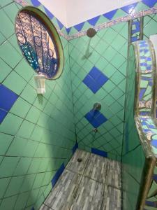 萨玛拉Casa Maiana的一间设有蓝色和绿色瓷砖墙壁和窗户的客房