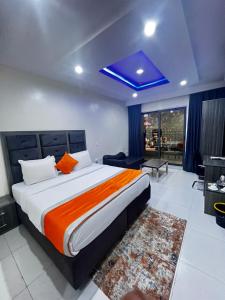 拉各斯De Rigg Place Embassy的一间卧室配有一张带橙色毯子的大床