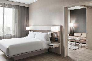 夏洛特AC Hotel by Marriott Charlotte SouthPark的卧室配有白色的床和沙发