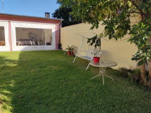 蒂格雷Casita Casa con parque, estacionamiento y pileta en Tigre的草原上带桌子的庭院