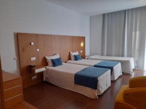 贝尔蒙特Belmonte Sinai Hotel的酒店客房 - 带两张带蓝色枕头的床