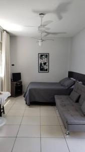 桑托斯Studio Frente à Praia Boqueirão的客厅配有床和沙发