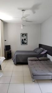 桑托斯Studio Frente à Praia Boqueirão的一间卧室配有一张床和一张沙发