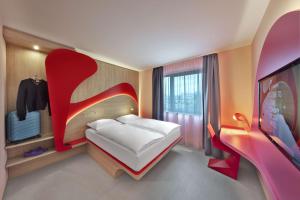 哈尔伯格摩斯prizeotel Munich-Airport的卧室配有白色床和红色床头板