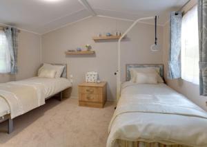 查珀尔圣伦纳兹Merryfield And Sandfield的一间卧室配有两张床和梳妆台。