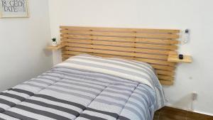 韦拉克鲁斯Loft en Veracruz的卧室内的一张床位,配有木制床头板