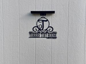 坦帕Torres Tiny Home Midtown WestTampa RJS的房屋护理室白色墙上的标志