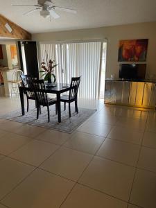 黎明城Cozy Guest House Florida, 5801的一间铺有瓷砖地板并配有桌椅的用餐室