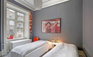 哥本哈根Copenhagen Apartment with excellent location的卧室配有两张床,墙上挂有一张海报
