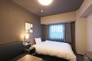 舞鹤市Hotel Route Inn Kyoto Maizuru -Nishi Maizuru Ekimae-的酒店客房设有床和窗户。