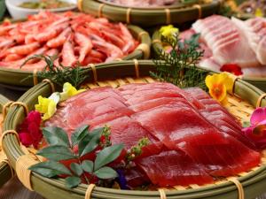 东伊豆町Atagawa Ocean Resort的餐桌上放有肉和蔬菜的盘子