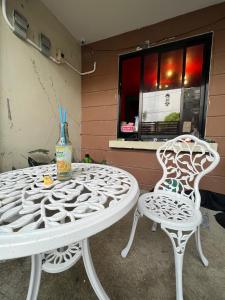 General TriasTaal cozy private homestay with OWN PRIVATE bathroom in General Trias - Pink Room的一张白色的桌子和两把椅子坐在窗边