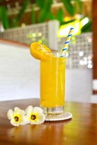 坎古37 Sunset Village Bali的一杯饮料,在桌子上放上橙子片,花朵