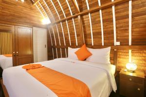 坎古37 Sunset Village Bali的一间卧室配有一张大白色床和橙色毯子