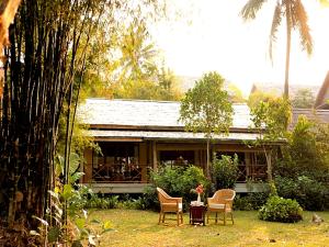琅勃拉邦梦中精品度假村的房屋前设有椅子和桌子