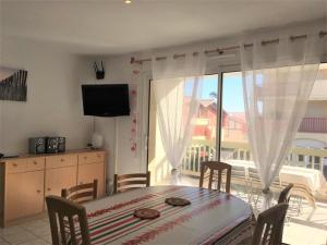 布科·莱斯白老城Appartement Vieux-Boucau-les-Bains, 2 pièces, 4 personnes - FR-1-379-74的一间带桌子的用餐室和一个阳台