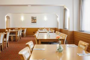 布尔诺OREA Hotel Voro Brno的用餐室配有木桌和椅子