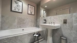 巴斯Leighton House - Boutique Guesthouse的浴室配有盥洗盆、浴缸和盥洗盆